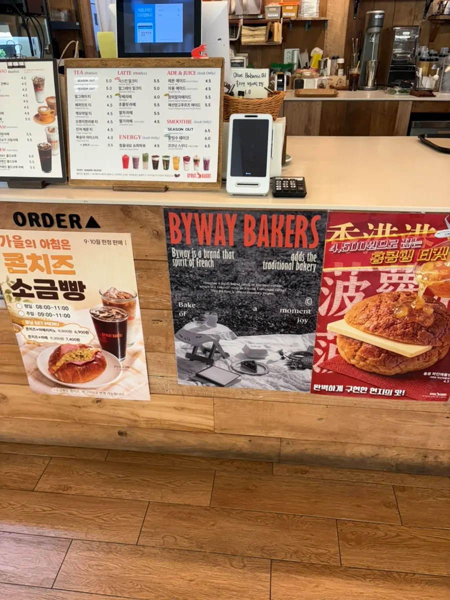 Drink menu board listing coffee, tea, and ades