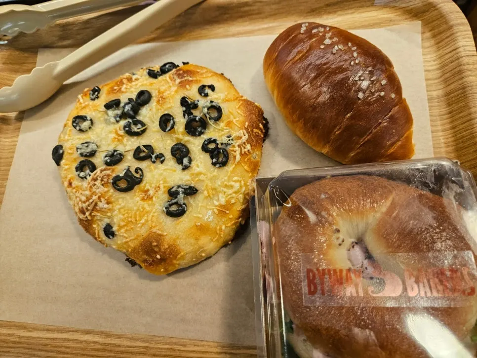 Focaccia, salt bread, and bagels on a tray
