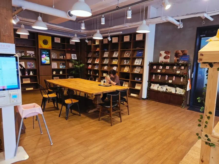 창가 좌석과 단체 테이블이 있는 카페 내부