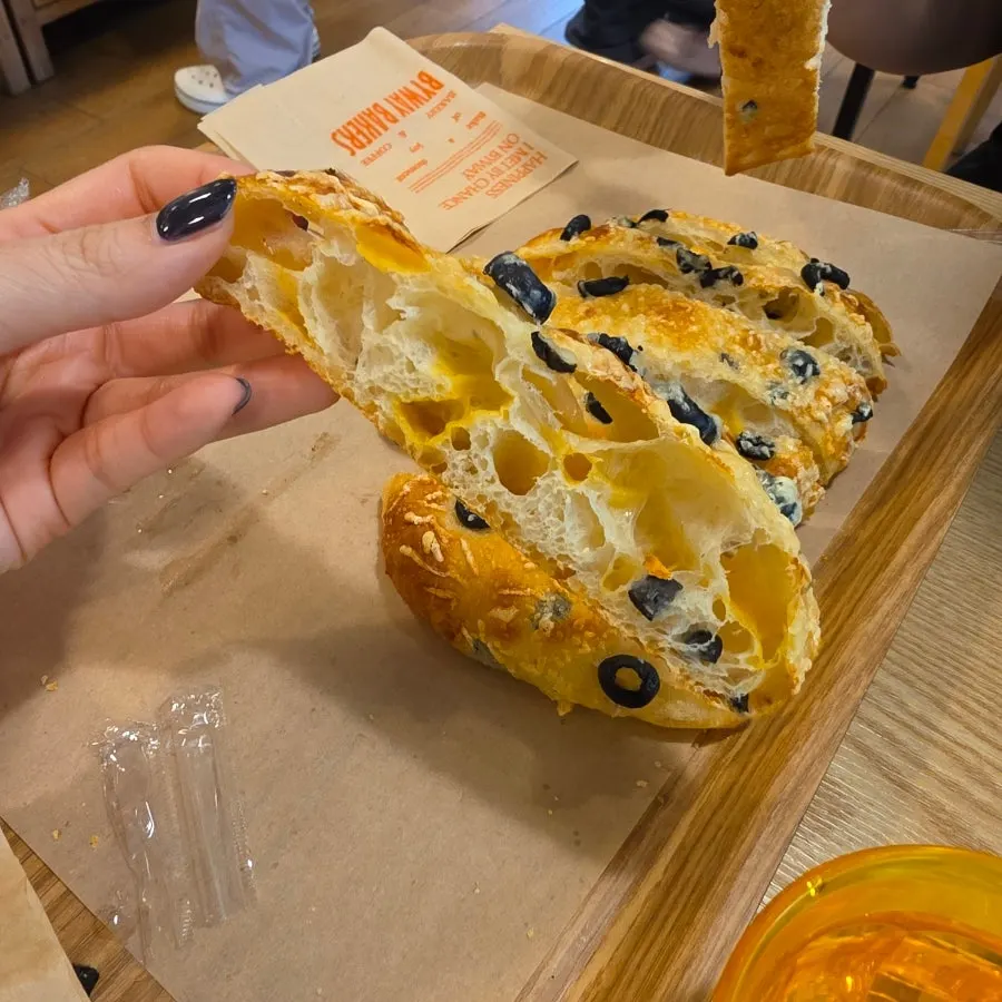 A torn piece of olive focaccia showing the inside texture