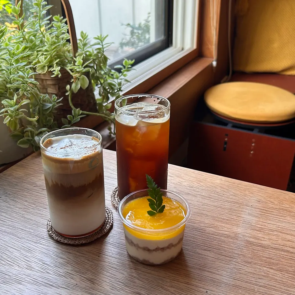Drinks and dessert next to window-side plants