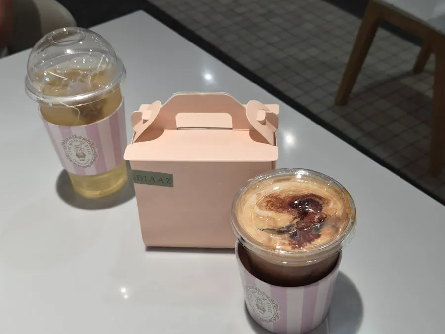 푸드코트 테이블에 올려둔 포장 케이크와 음료