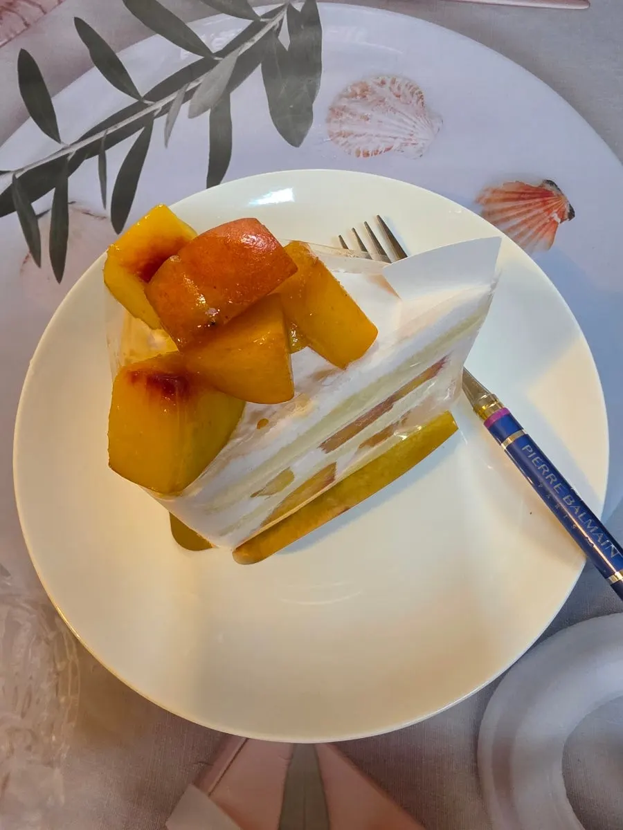 Whipped cream cake slice with peach