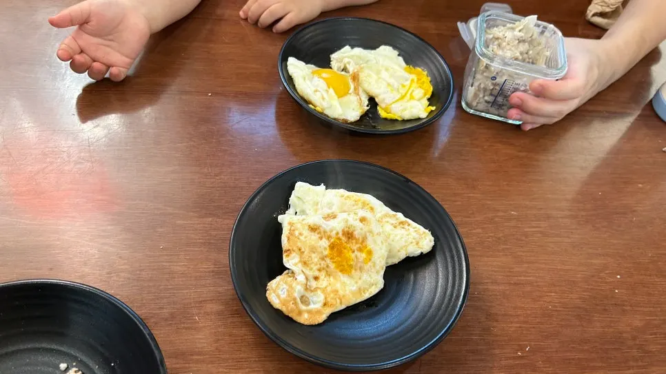 Unlimited fried eggs being grilled