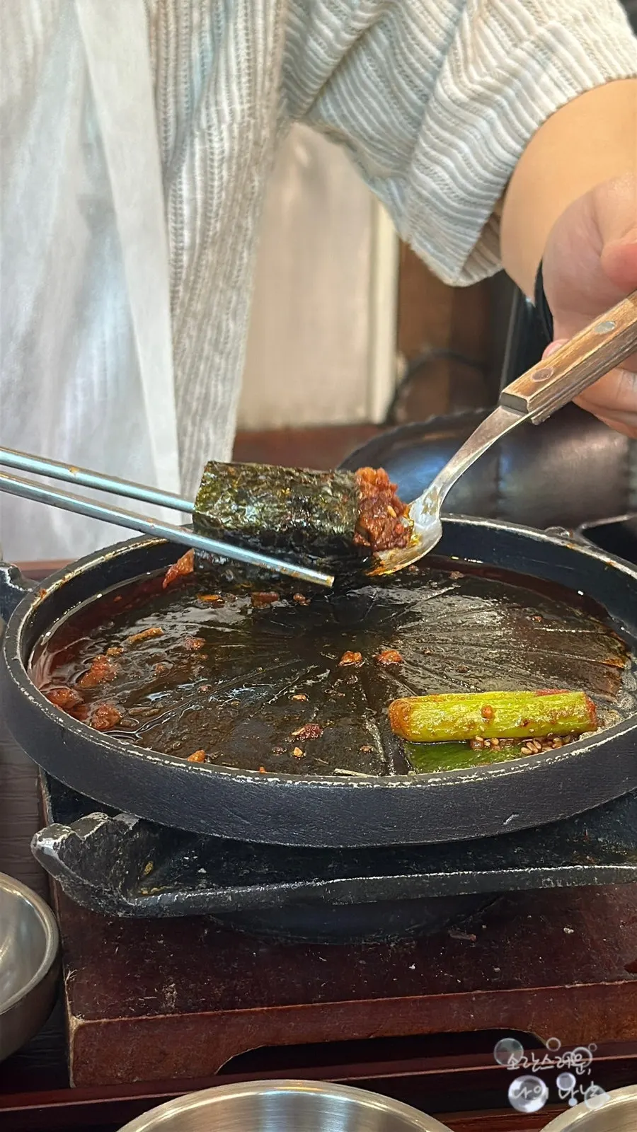 Dipping tangsuyuk into the tangy sauce