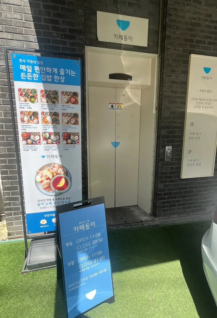 Entrance sign guiding to Cafe Dongi on the 2nd floor