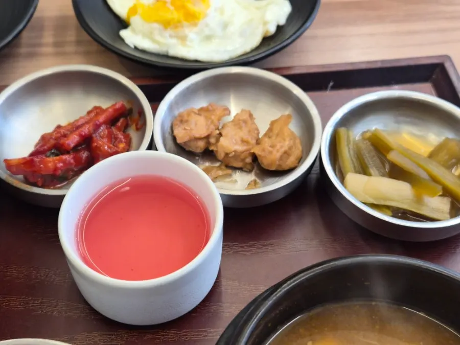 Neatly arranged side dishes and doenjang jjigae in a stone pot
