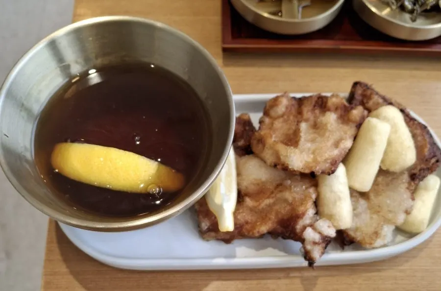 A plate of mini sweet and sour pork with sauce
