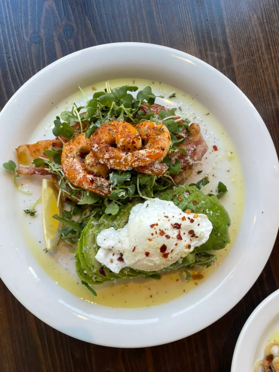 Plated avocado shrimp sandwich