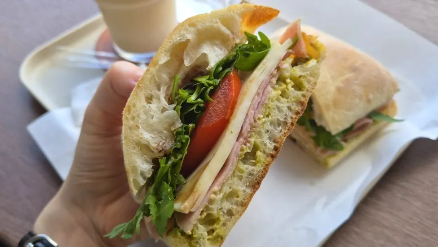 Coffee and a sandwich set on a window table with fortress view