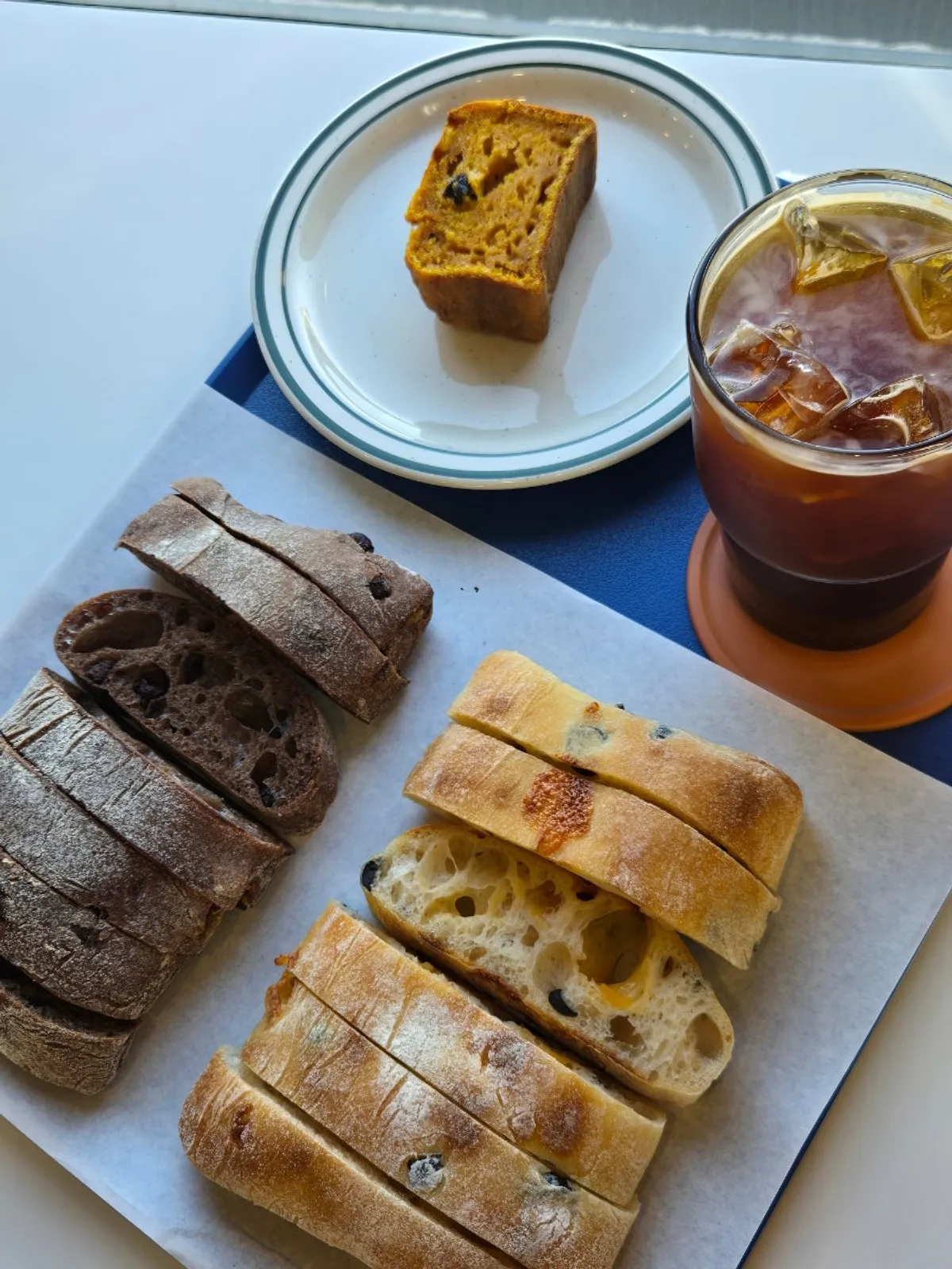 Choco fig and olive cheese ciabatta with iced americano on the table