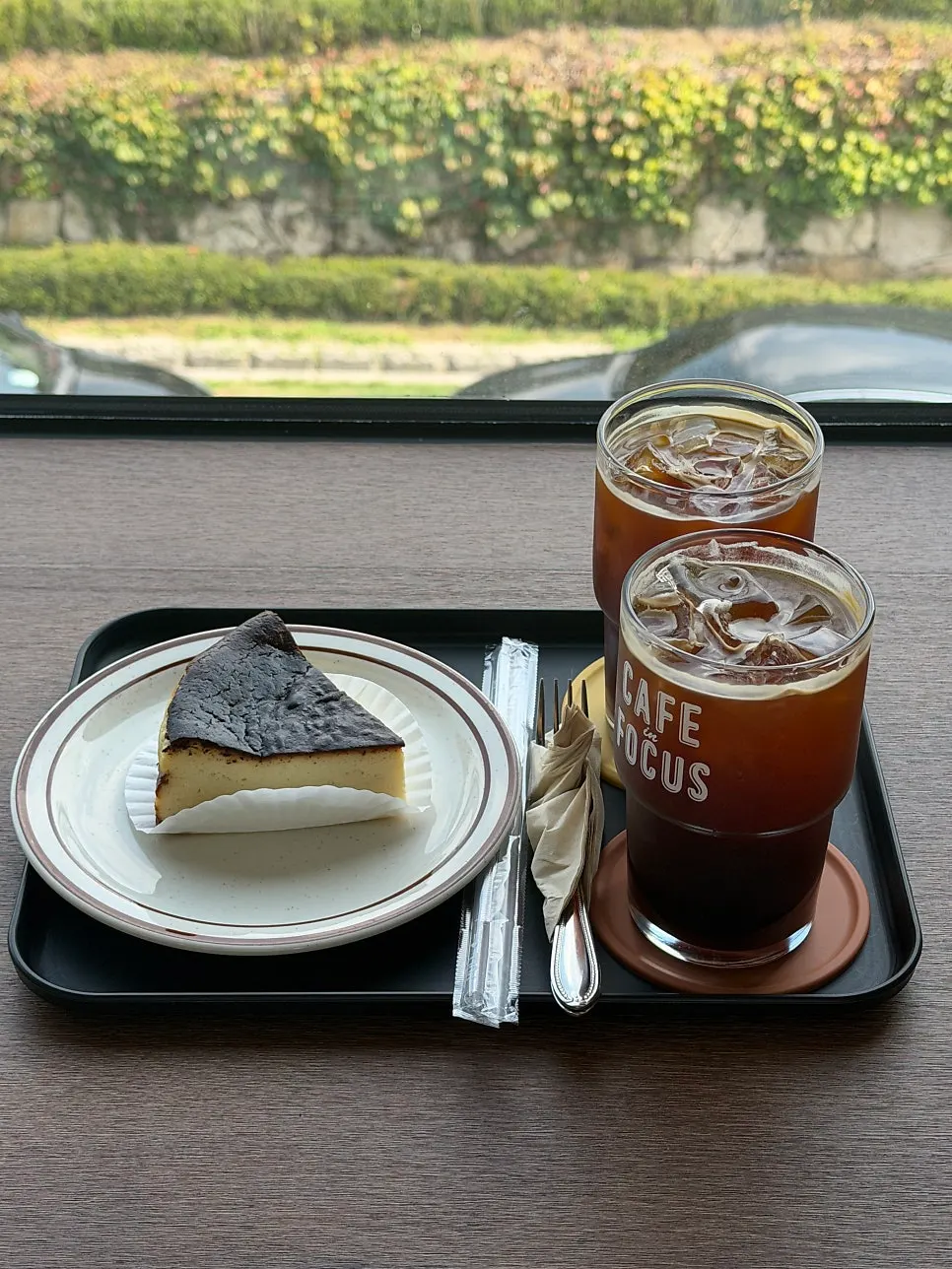 Americano and Basque cheesecake set on a window table
