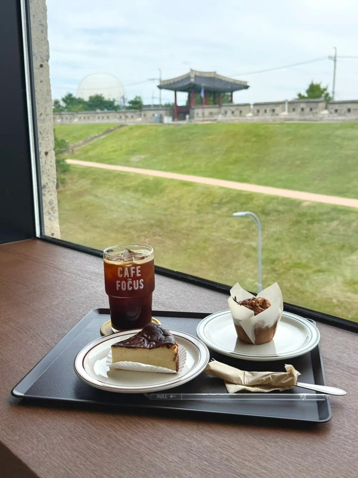 Drinks and dessert set on a table by the fortress-view window