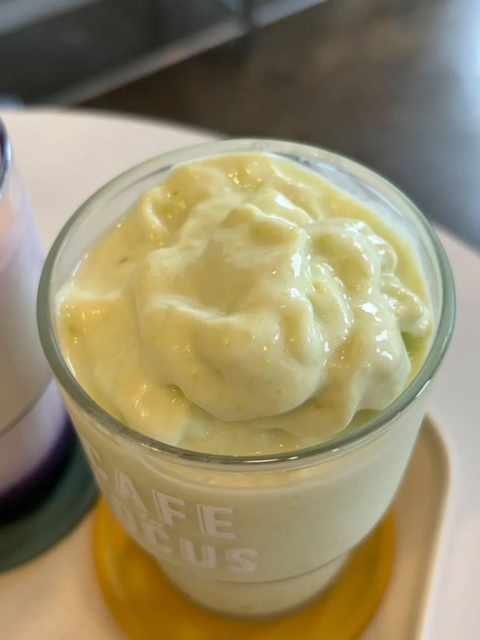 Table setting with the avocado smoothie, ube latte, and egg scone order