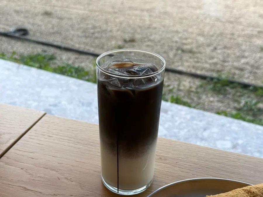 Black latte with black coffee poured over milk