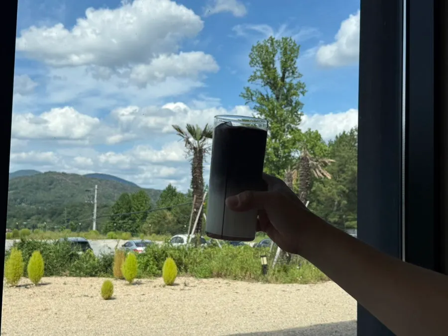 Black latte set by the forest-view window