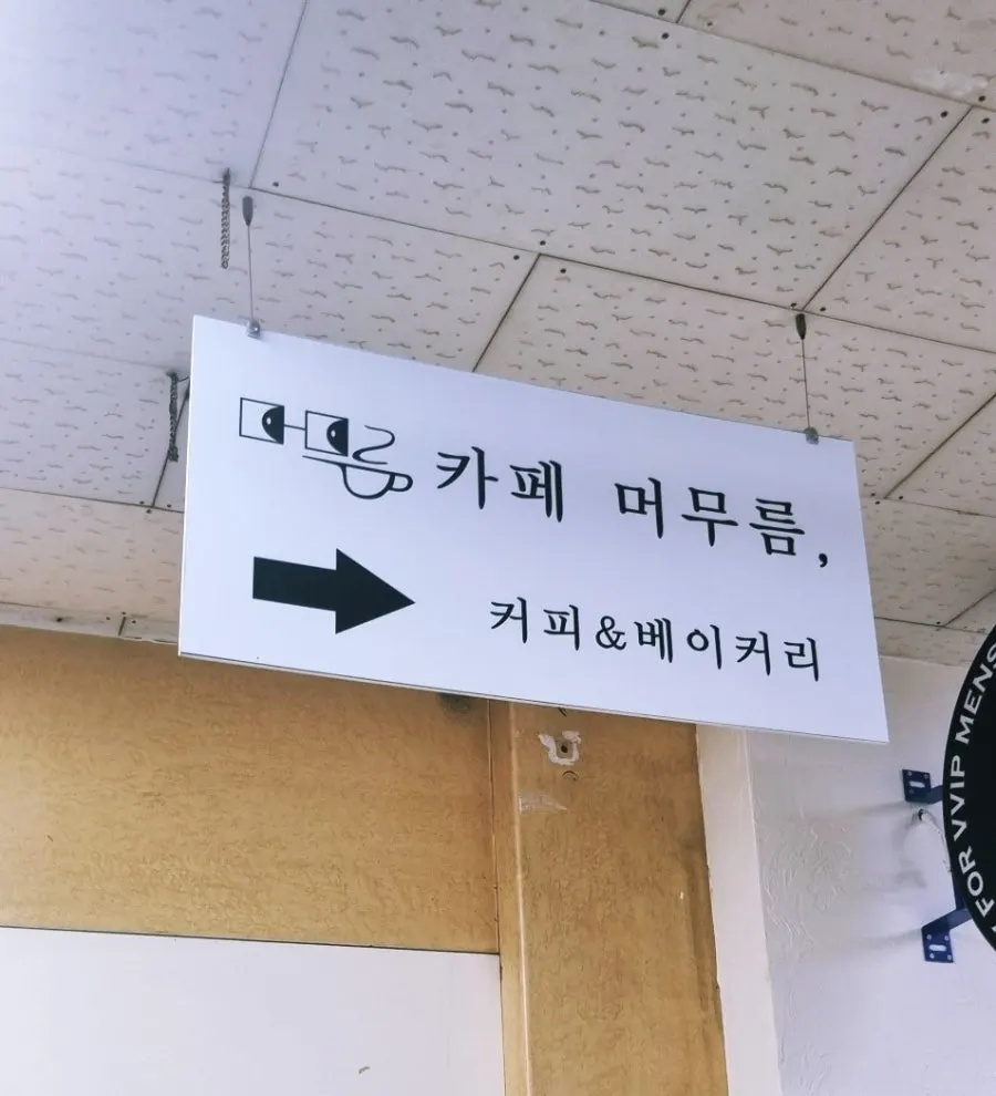 2층으로 오르는 계단 천장의 카페 머무름 안내판