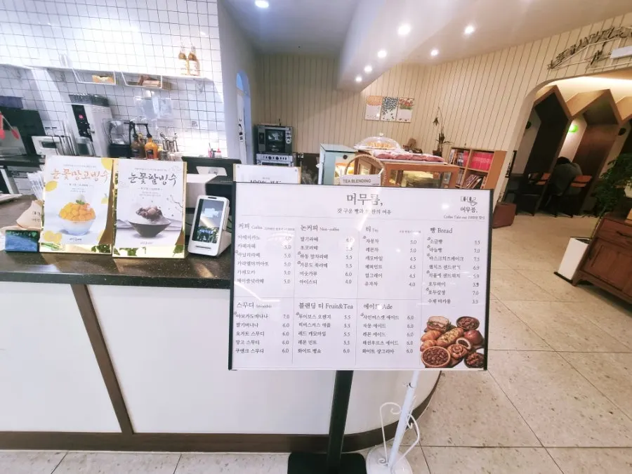 카운터 옆에 세워진 카페 머무름 메뉴판