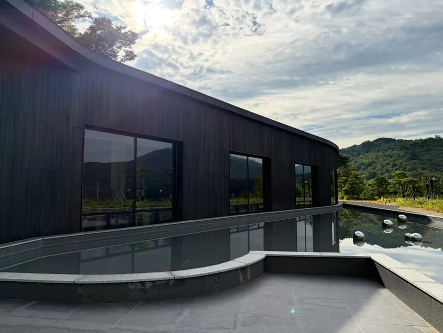 Exterior of MUG with its black building and water feature