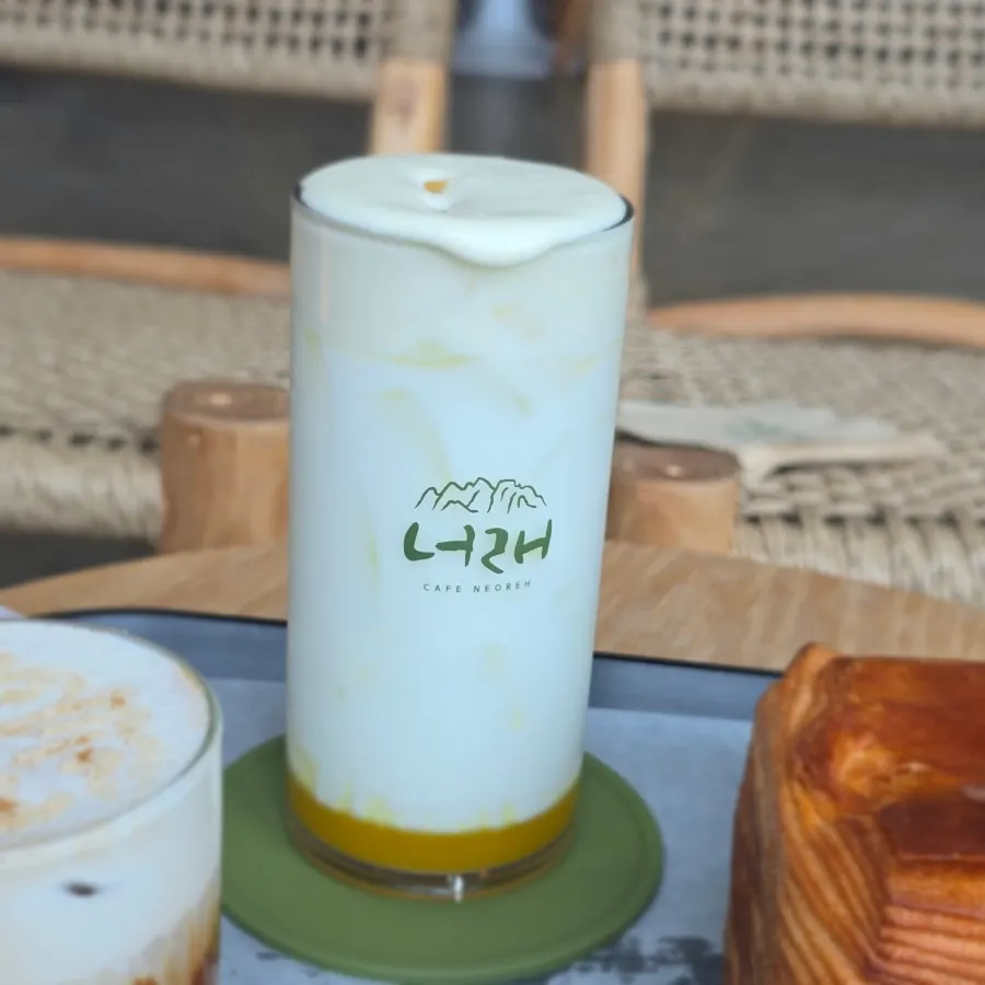 A cup of Neorae Latte topped with cream