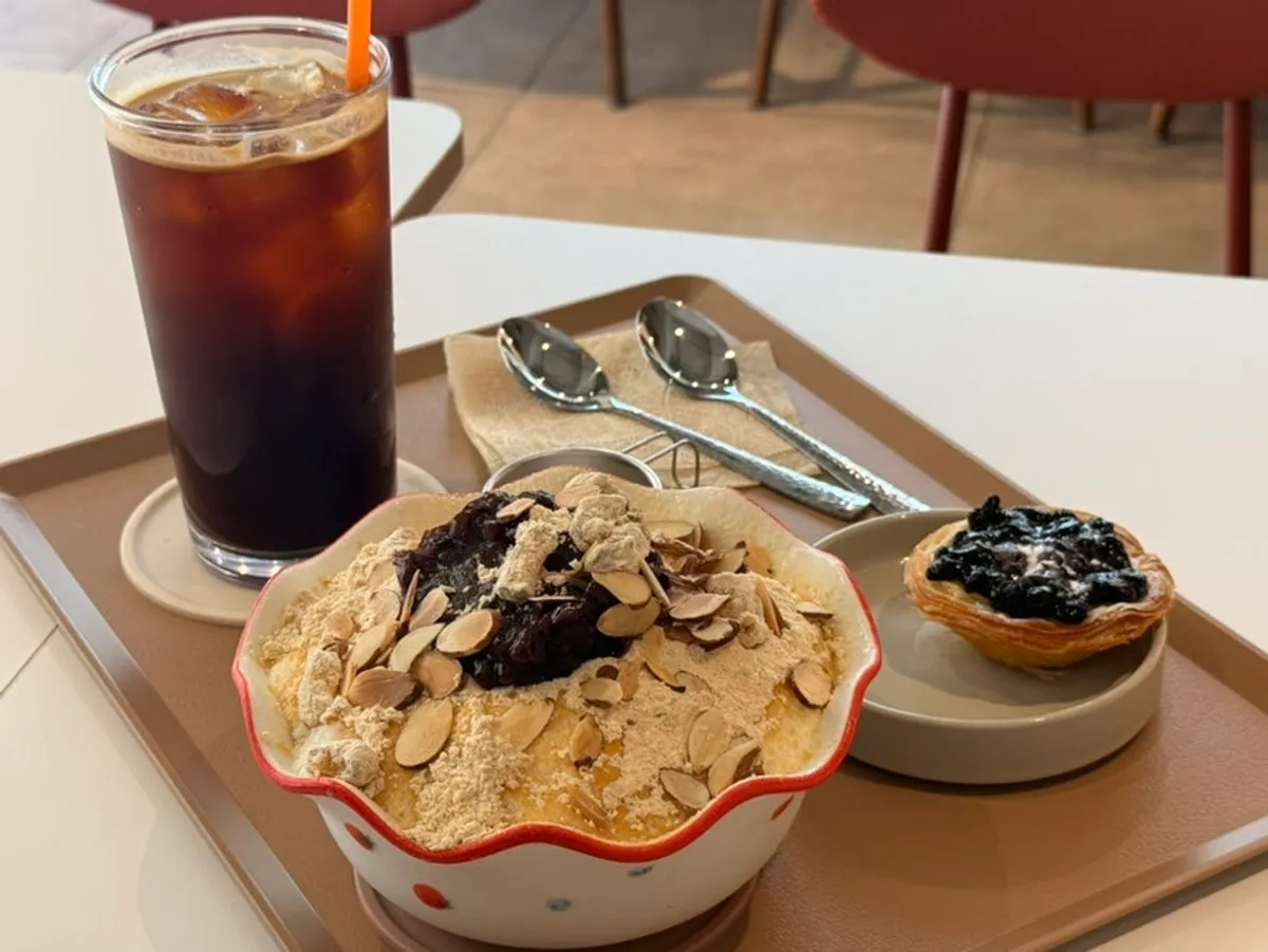 Snow ice bingsu, americano, and egg tart set out at the table