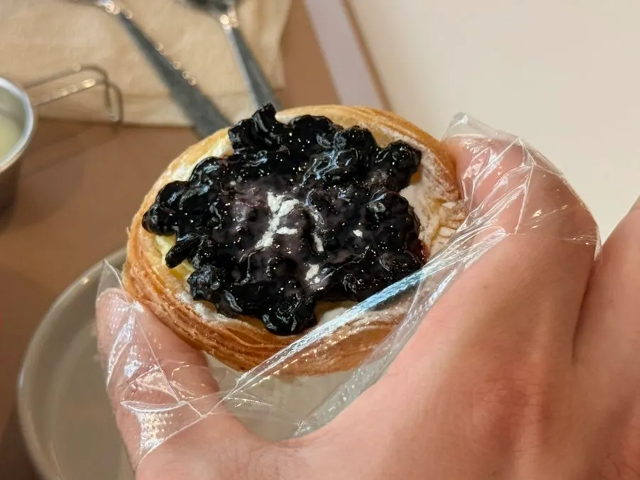 Blueberry cream cheese egg tart held by hand
