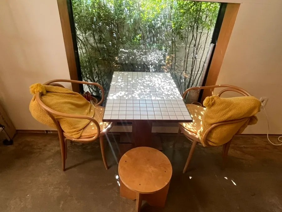 Cute two-person table with greenery visible outside the window