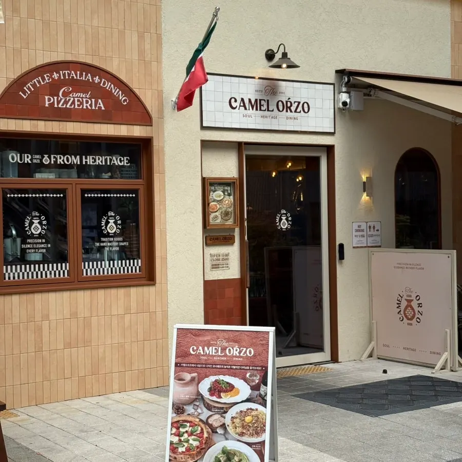 Entrance exterior with the Italian flag and CAMEL ORZO logo