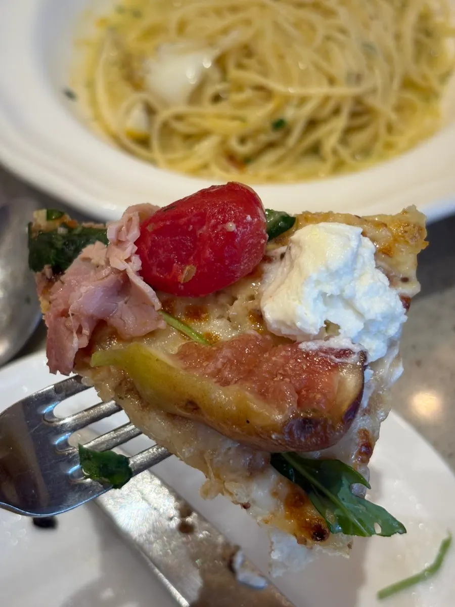 Lifting up a slice of the fig fresco pizza