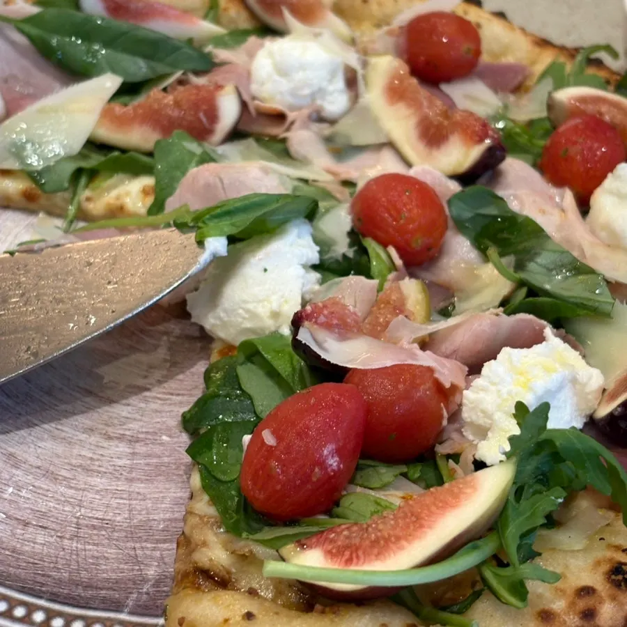 Full view of the fig wood-fired pizza with abundant toppings