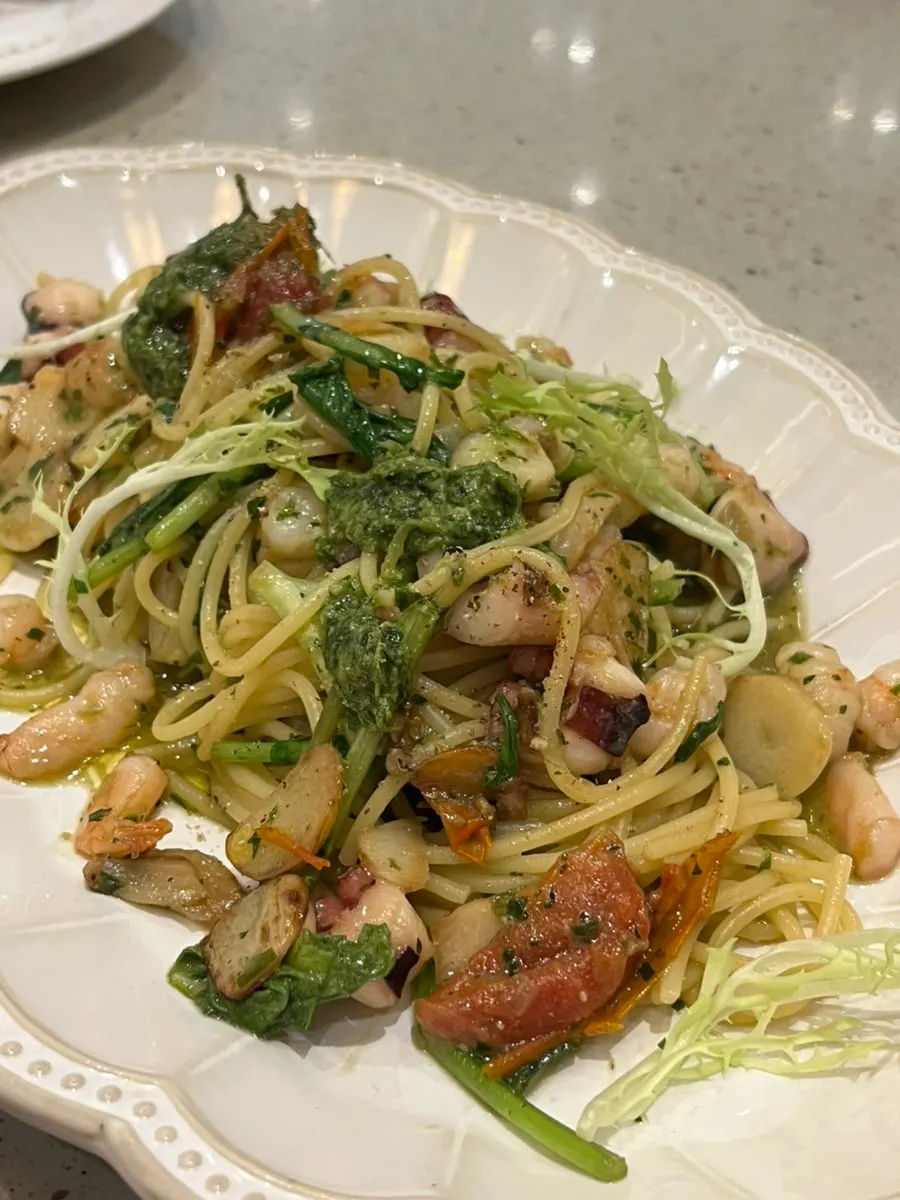 A plate of octopus and shrimp arugula pasta