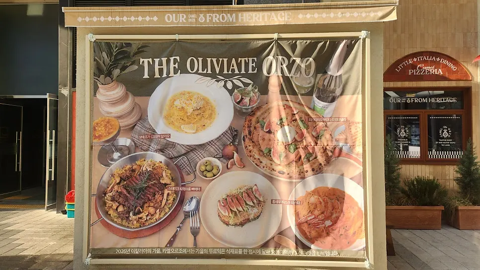 Exterior of Camel Orzo's building with an Italian food photo displayed