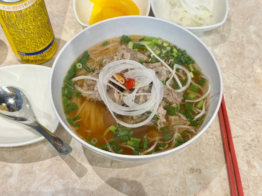 Kkamon signature pho topped with meat and bean sprouts