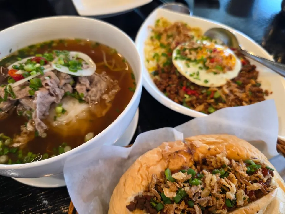 Table spread with brisket pho, banh mi, and fried rice