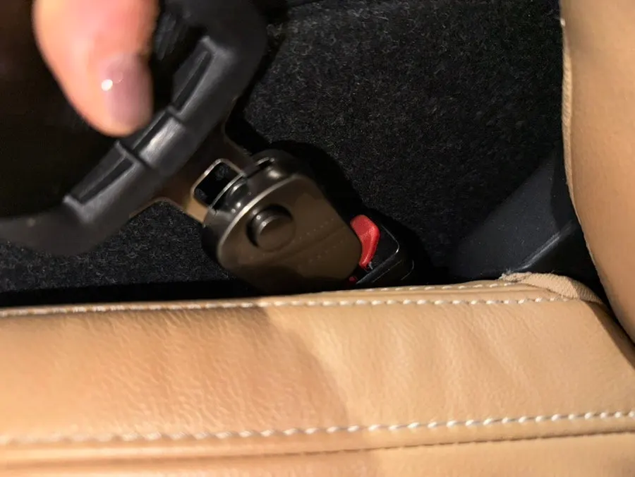 Seat belt extension clip checked for secure fit after installation