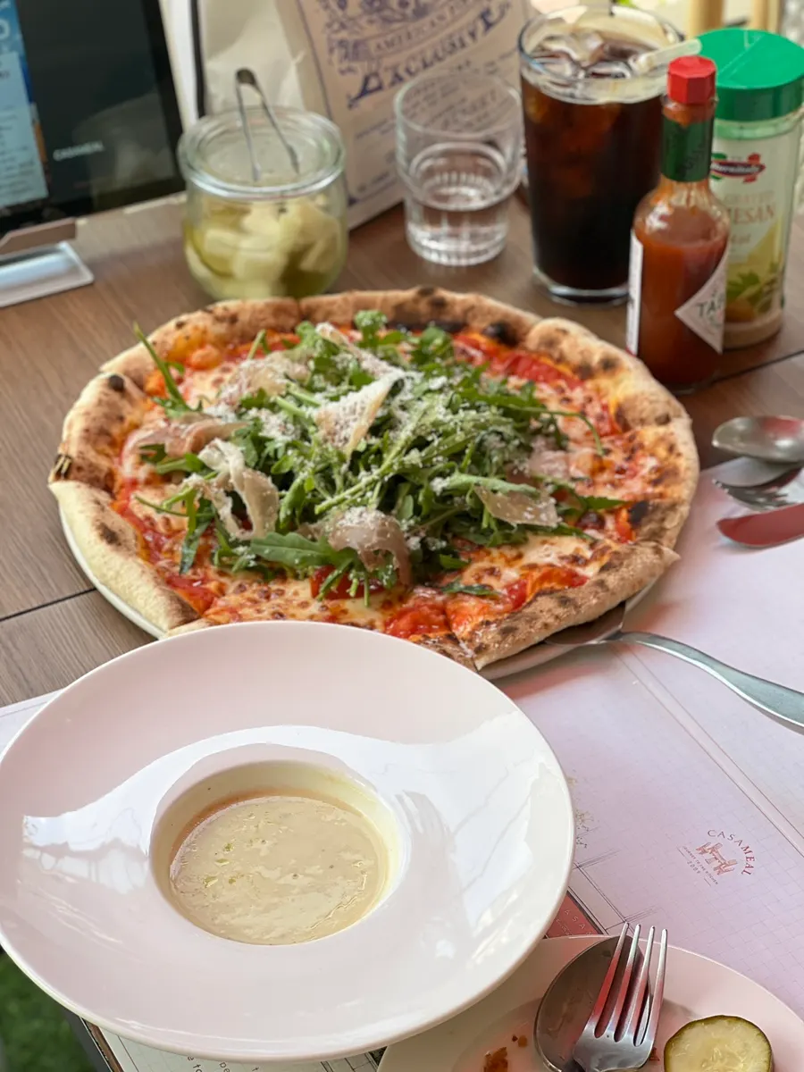 Wood-fired pizza topped with rocket and prosciutto