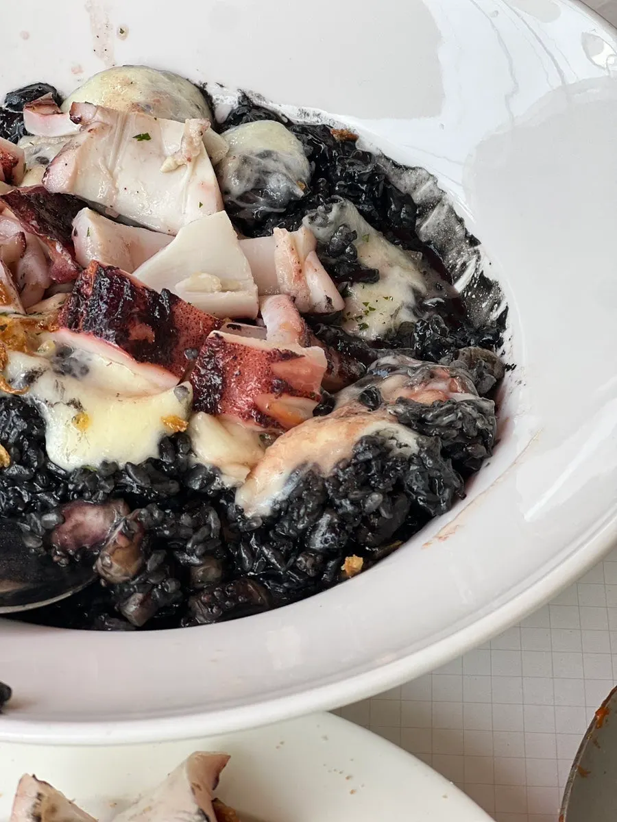 Squid ink risotto with the squid cut using scissors