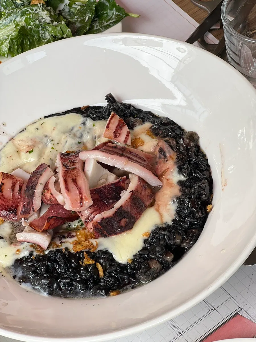 A spoonful of squid ink risotto with cheese