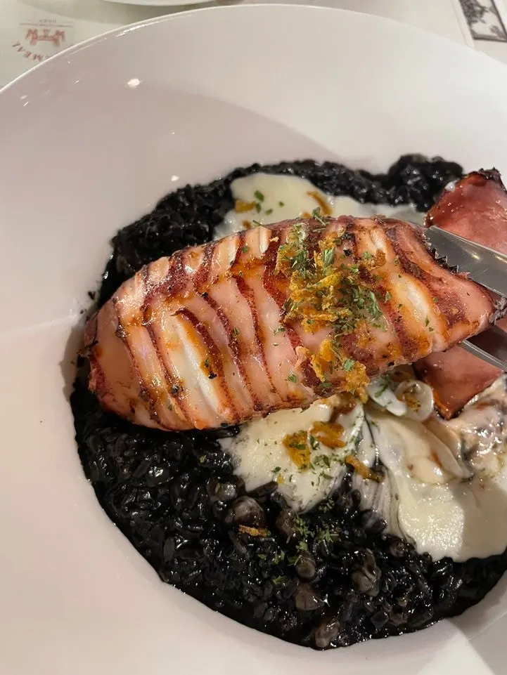 Close-up of the large whole squid on the ink risotto