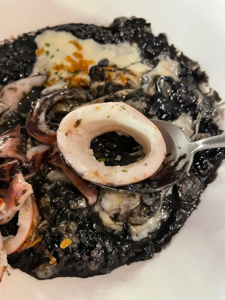 Whole squid cut into bite-sized pieces over the ink risotto