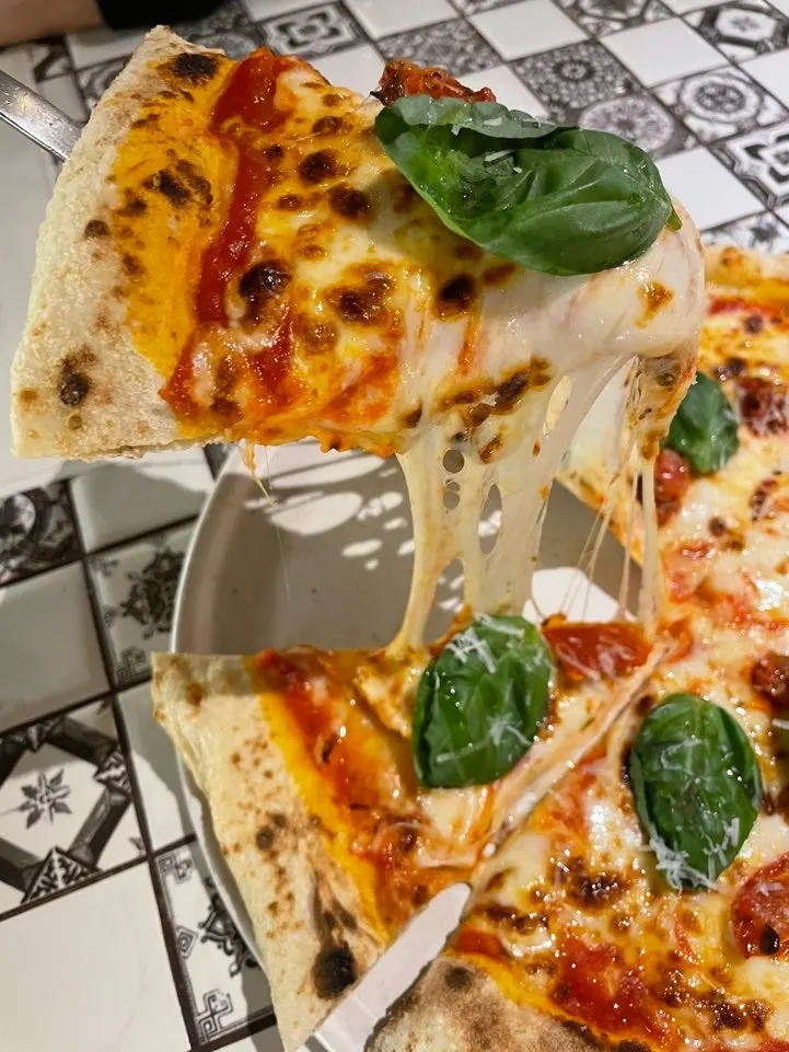 A slice of Margherita pizza topped with basil