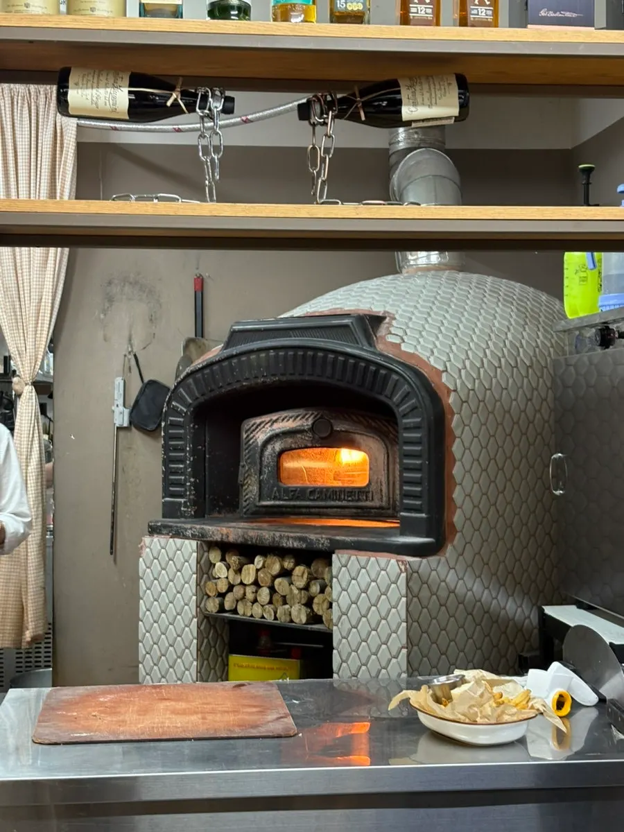 Rocket prosciutto pizza fresh out of the wood-fired oven