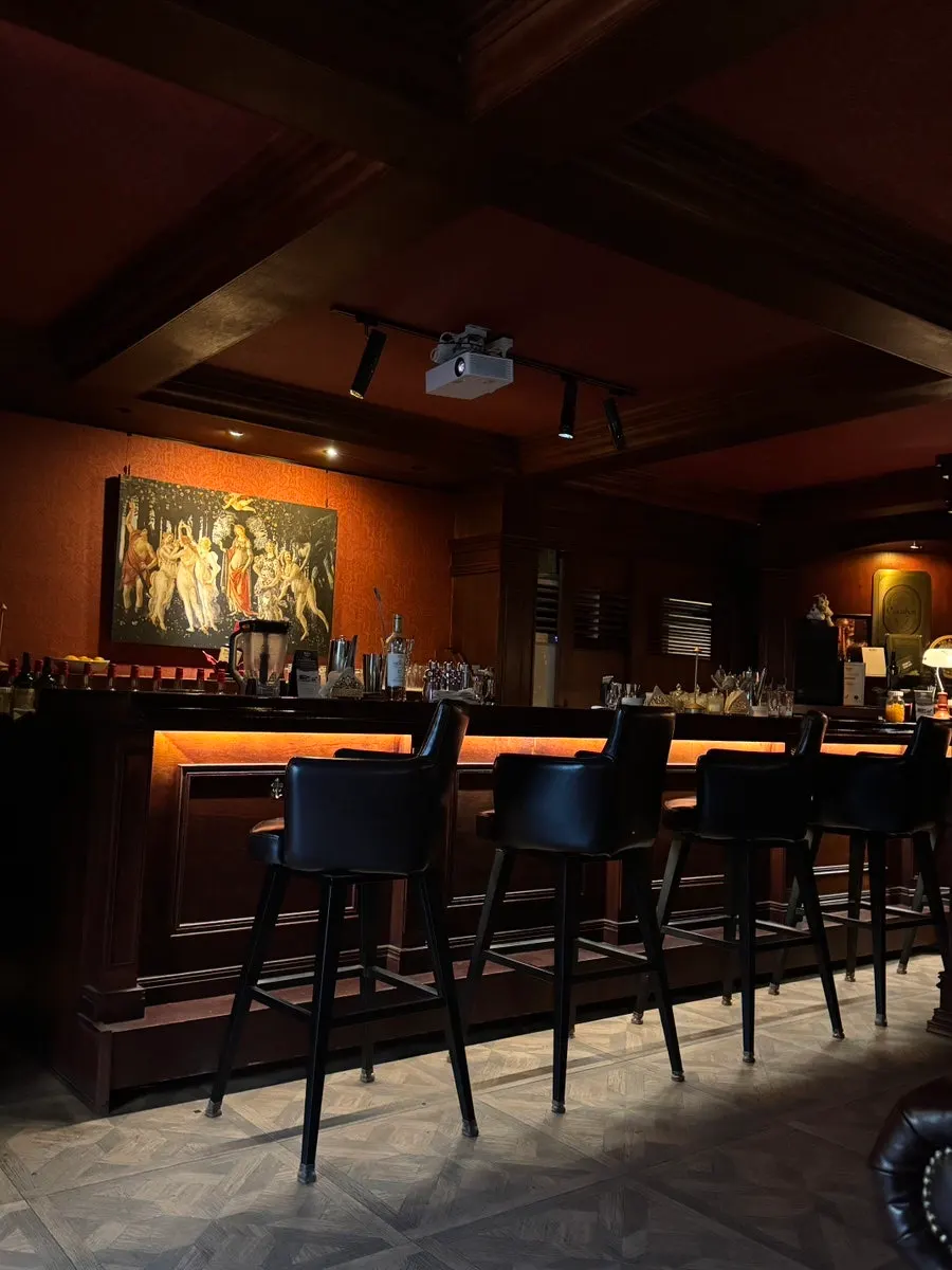 Interior of the cocktail bar with dark wood tones and soft lighting