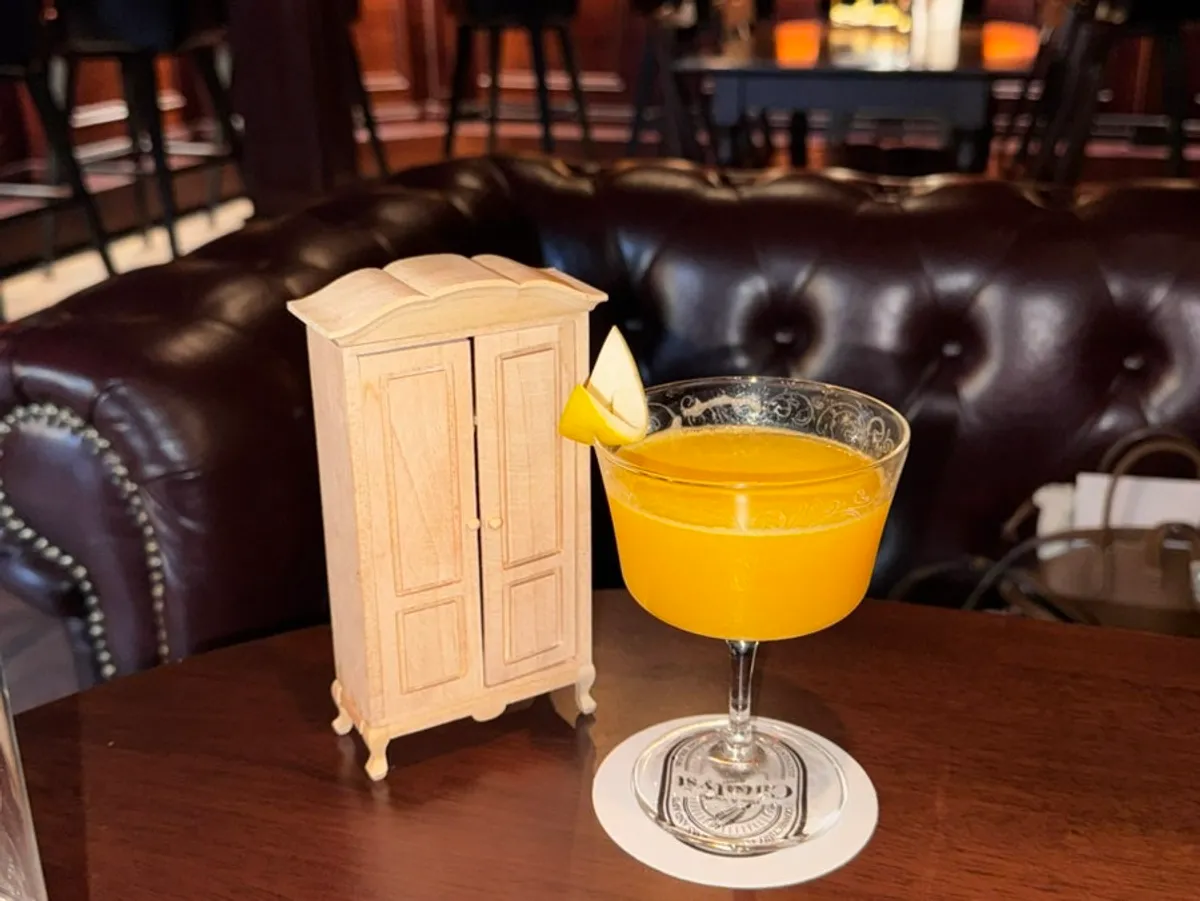 Orange-hued About Time cocktail with movie props