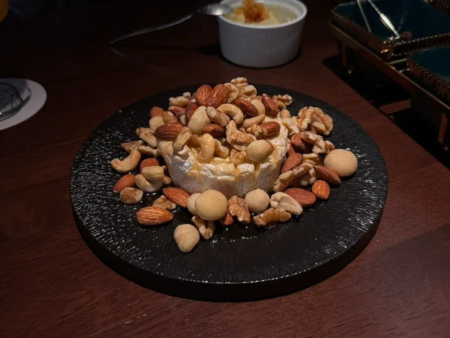 Grilled brie topped with a generous amount of nuts