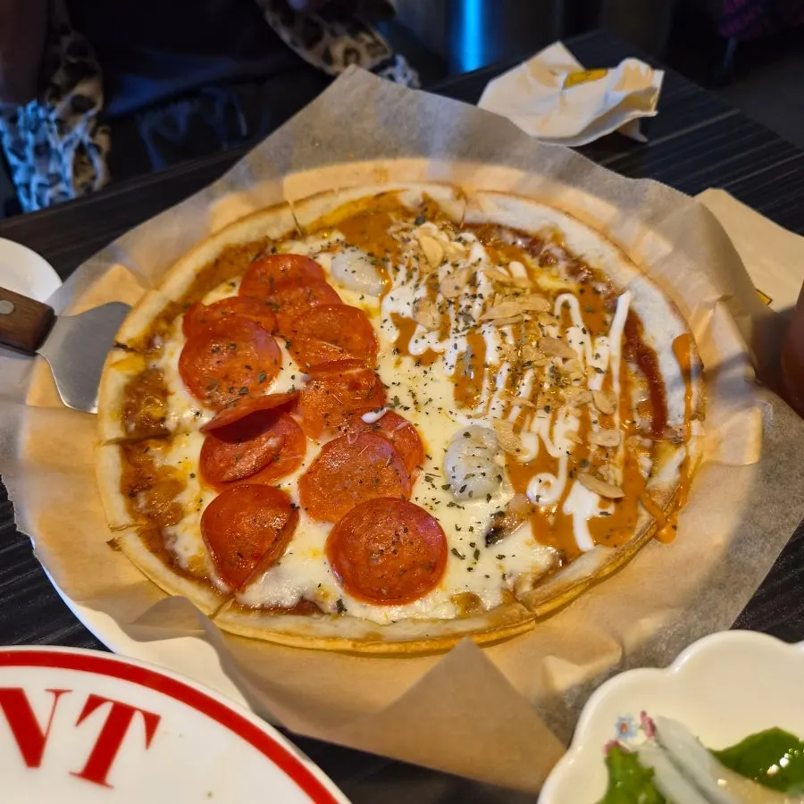 A slice of thin-crust pizza with stretchy cheese