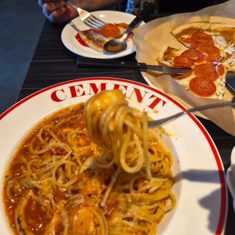 A table where pizza and pasta were eaten alternately