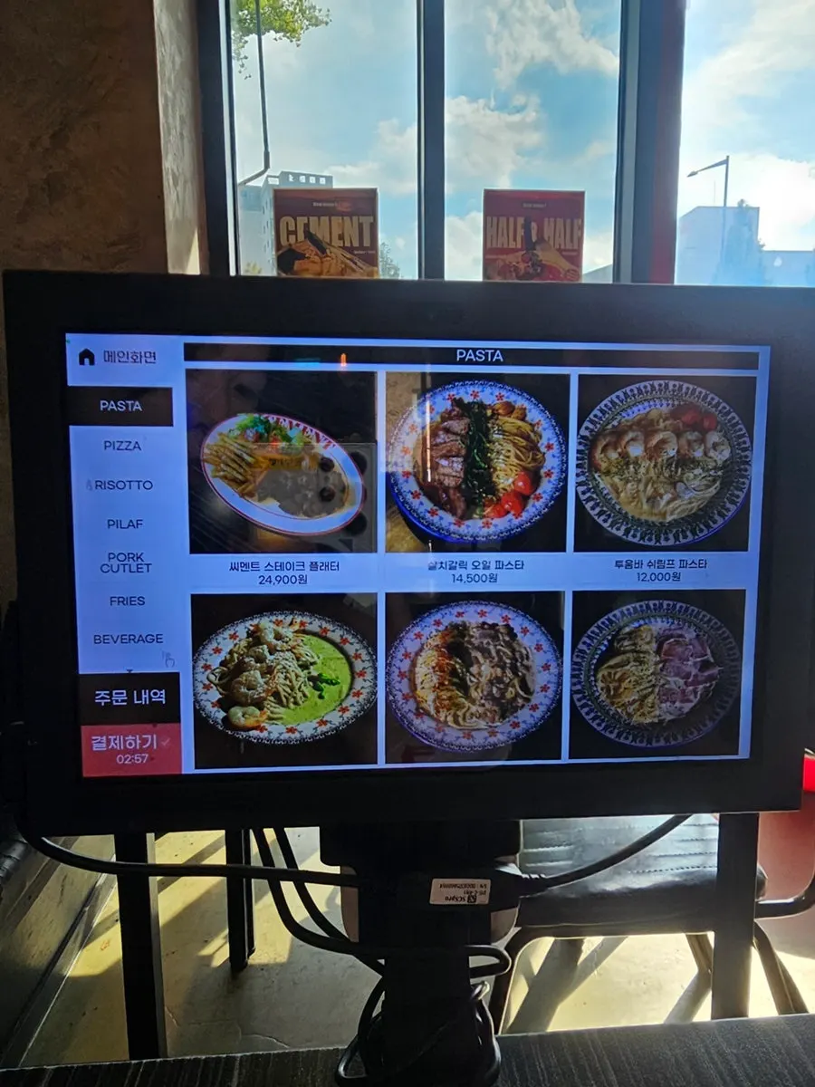 Menu board showing pasta and pizza options