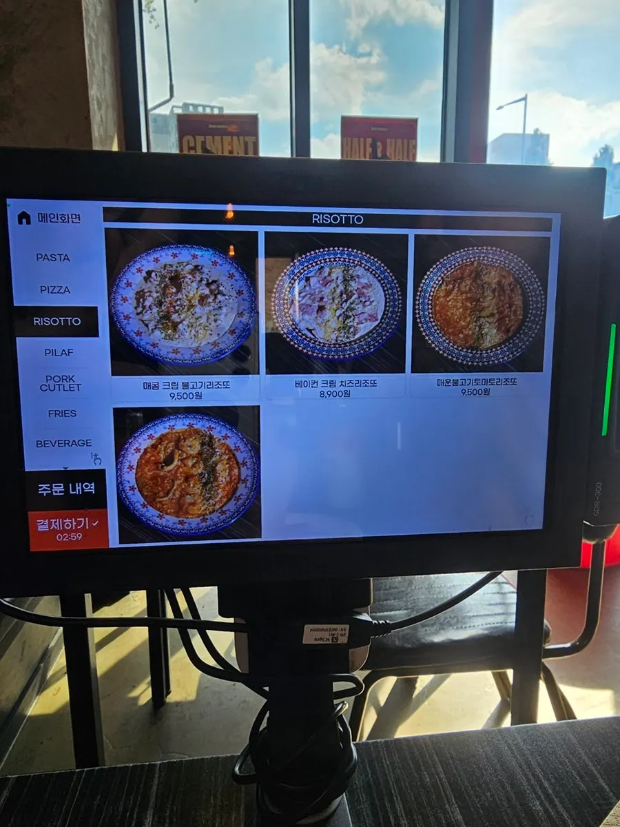 Menu board with risotto and pizza prices