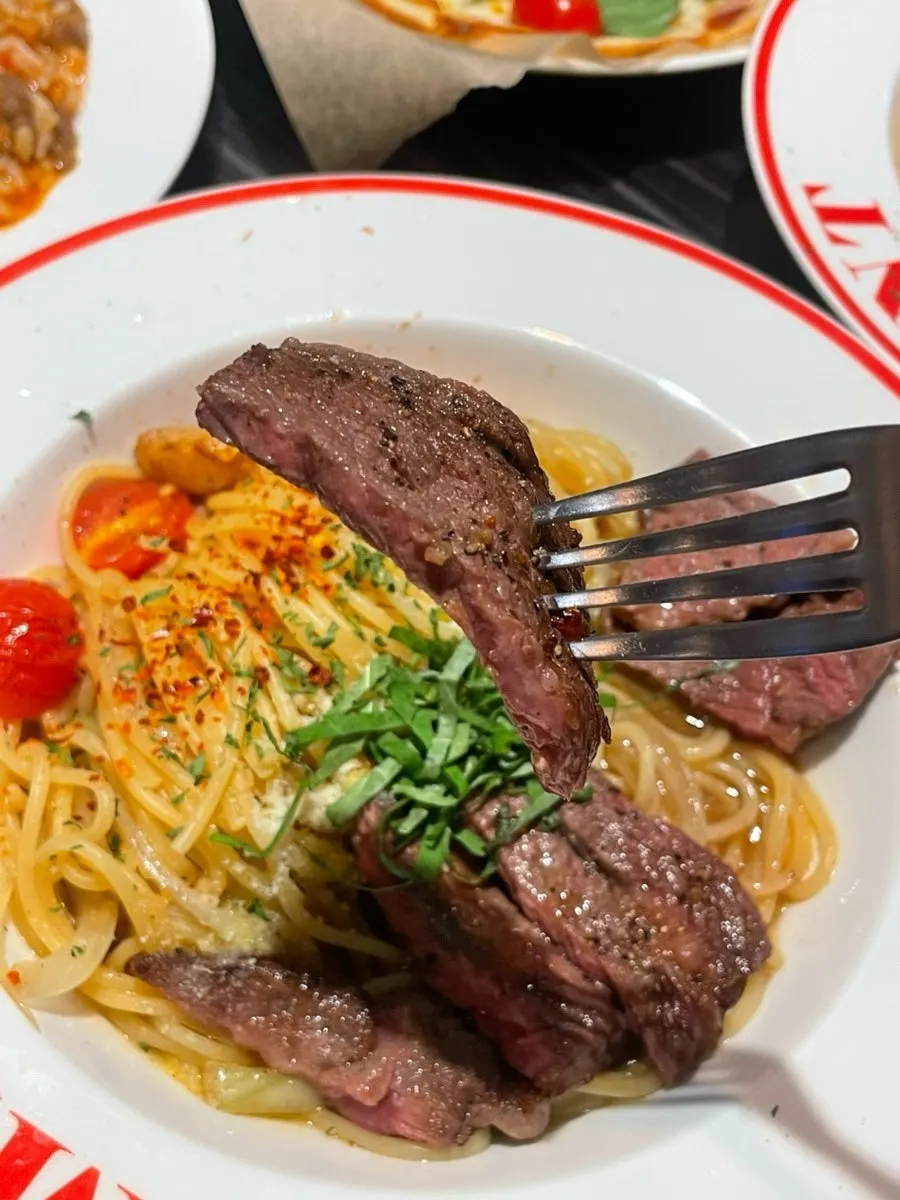 Striploin and noodles twirled together in the oil pasta
